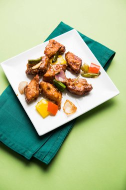 Baharatlı Paneer veya kuru biber paneer veya paneer tikka veya süzme peynir, kırmızı biber ve soğan, favori Hint başlangıç menüsü, seçici odak ile beyaz yemek servis