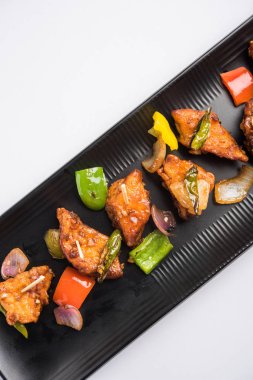 Baharatlı Paneer veya kuru biber paneer veya paneer tikka veya süzme peynir, kırmızı biber ve soğan, favori Hint başlangıç menüsü, seçici odak ile beyaz yemek servis