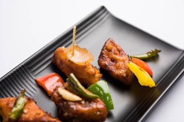 Baharatlı Paneer veya kuru biber paneer veya paneer tikka veya süzme peynir, kırmızı biber ve soğan, favori Hint başlangıç menüsü, seçici odak ile beyaz yemek servis