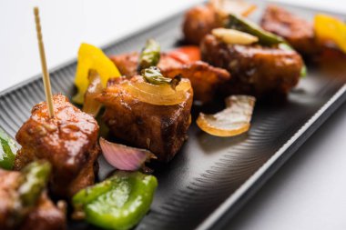 Baharatlı Paneer veya kuru biber paneer veya paneer tikka veya süzme peynir, kırmızı biber ve soğan, favori Hint başlangıç menüsü, seçici odak ile beyaz yemek servis