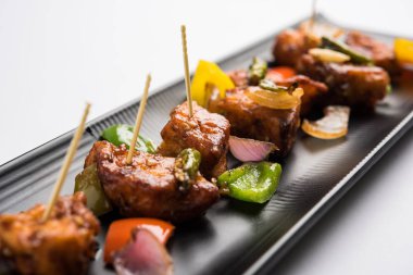 Baharatlı Paneer veya kuru biber paneer veya paneer tikka veya süzme peynir, kırmızı biber ve soğan, favori Hint başlangıç menüsü, seçici odak ile beyaz yemek servis