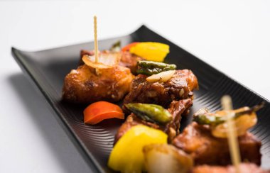 Baharatlı Paneer veya kuru biber paneer veya paneer tikka veya süzme peynir, kırmızı biber ve soğan, favori Hint başlangıç menüsü, seçici odak ile beyaz yemek servis