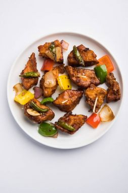 Baharatlı Paneer veya kuru biber paneer veya paneer tikka veya süzme peynir, kırmızı biber ve soğan, favori Hint başlangıç menüsü, seçici odak ile beyaz yemek servis