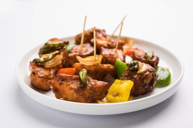 Baharatlı Paneer veya kuru biber paneer veya paneer tikka veya süzme peynir, kırmızı biber ve soğan, favori Hint başlangıç menüsü, seçici odak ile beyaz yemek servis