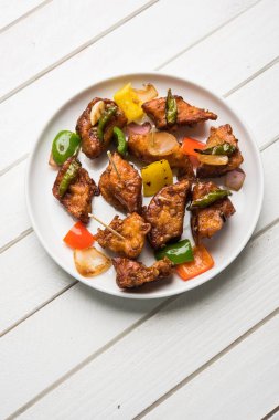 Baharatlı Paneer veya kuru biber paneer veya paneer tikka veya süzme peynir, kırmızı biber ve soğan, favori Hint başlangıç menüsü, seçici odak ile beyaz yemek servis