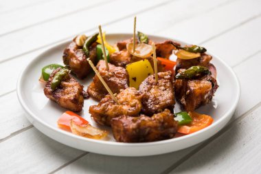 Baharatlı Paneer veya kuru biber paneer veya paneer tikka veya süzme peynir, kırmızı biber ve soğan, favori Hint başlangıç menüsü, seçici odak ile beyaz yemek servis