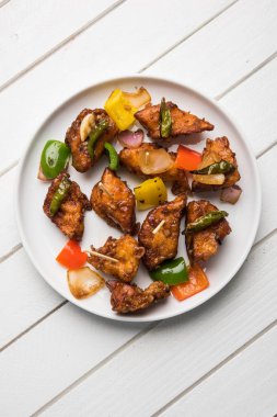 Baharatlı Paneer veya kuru biber paneer veya paneer tikka veya süzme peynir, kırmızı biber ve soğan, favori Hint başlangıç menüsü, seçici odak ile beyaz yemek servis