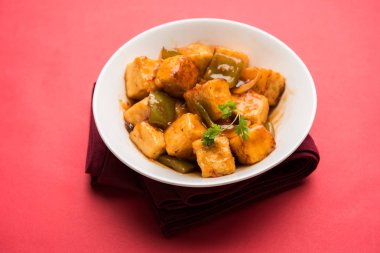 Baharatlı Paneer veya kuru biber paneer veya paneer tikka veya süzme peynir, kırmızı biber ve soğan, favori Hint başlangıç menüsü, seçici odak ile beyaz yemek servis