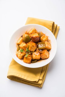 Baharatlı Paneer veya kuru biber paneer veya paneer tikka veya süzme peynir, kırmızı biber ve soğan, favori Hint başlangıç menüsü, seçici odak ile beyaz yemek servis