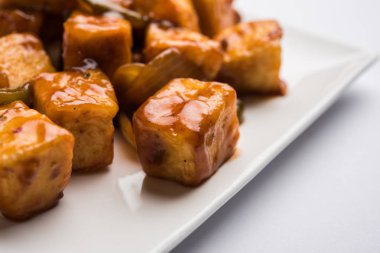 Baharatlı Paneer veya kuru biber paneer veya paneer tikka veya süzme peynir, kırmızı biber ve soğan, favori Hint başlangıç menüsü, seçici odak ile beyaz yemek servis