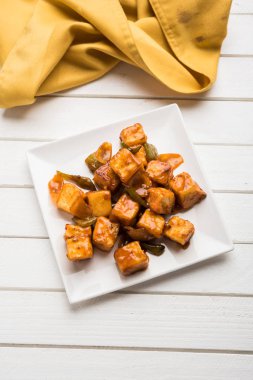 Baharatlı Paneer veya kuru biber paneer veya paneer tikka veya süzme peynir, kırmızı biber ve soğan, favori Hint başlangıç menüsü, seçici odak ile beyaz yemek servis
