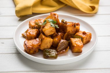 Baharatlı Paneer veya kuru biber paneer veya paneer tikka veya süzme peynir, kırmızı biber ve soğan, favori Hint başlangıç menüsü, seçici odak ile beyaz yemek servis
