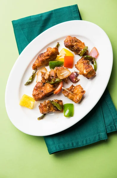 Baharatlı Paneer veya kuru biber paneer veya paneer tikka veya süzme peynir, kırmızı biber ve soğan, favori Hint başlangıç menüsü, seçici odak ile beyaz yemek servis