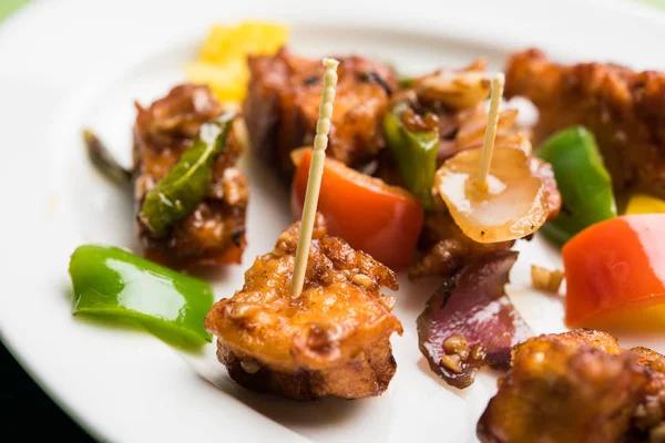 Baharatlı Paneer veya kuru biber paneer veya paneer tikka veya süzme peynir, kırmızı biber ve soğan, favori Hint başlangıç menüsü, seçici odak ile beyaz yemek servis