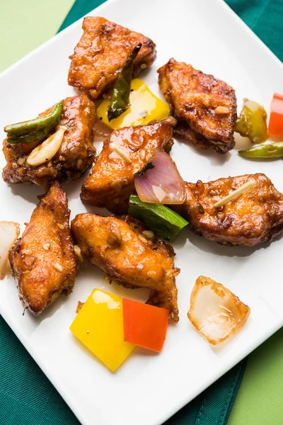 Baharatlı Paneer veya kuru biber paneer veya paneer tikka veya süzme peynir, kırmızı biber ve soğan, favori Hint başlangıç menüsü, seçici odak ile beyaz yemek servis