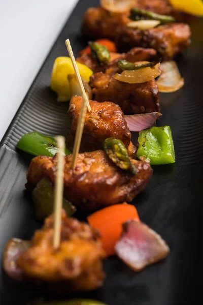 Baharatlı Paneer veya kuru biber paneer veya paneer tikka veya süzme peynir, kırmızı biber ve soğan, favori Hint başlangıç menüsü, seçici odak ile beyaz yemek servis