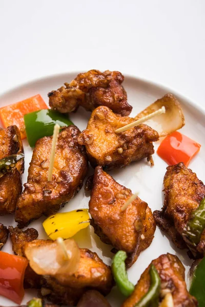 Baharatlı Paneer veya kuru biber paneer veya paneer tikka veya süzme peynir, kırmızı biber ve soğan, favori Hint başlangıç menüsü, seçici odak ile beyaz yemek servis