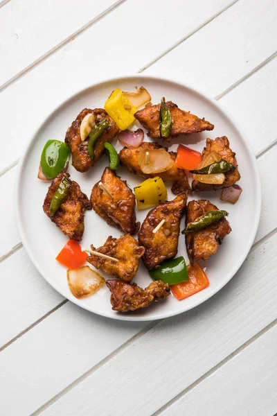 Baharatlı Paneer veya kuru biber paneer veya paneer tikka veya süzme peynir, kırmızı biber ve soğan, favori Hint başlangıç menüsü, seçici odak ile beyaz yemek servis