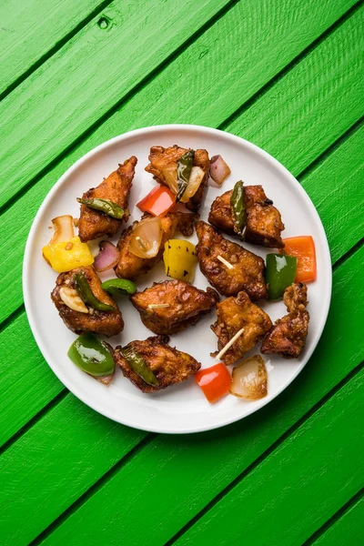 Baharatlı Paneer veya kuru biber paneer veya paneer tikka veya süzme peynir, kırmızı biber ve soğan, favori Hint başlangıç menüsü, seçici odak ile beyaz yemek servis