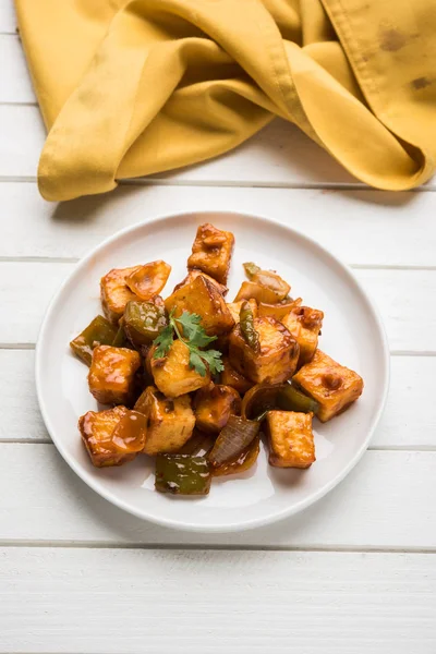 Baharatlı Paneer veya kuru biber paneer veya paneer tikka veya süzme peynir, kırmızı biber ve soğan, favori Hint başlangıç menüsü, seçici odak ile beyaz yemek servis