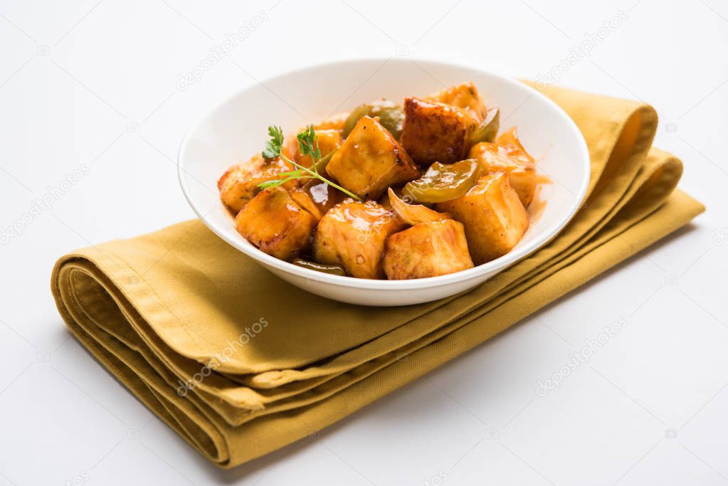 Spicy Paneer or dry chilli paneer or paneer tikka or cottage cheese, served in white Dish with capsicum and onion, favourite indian starter menu, selective focus
