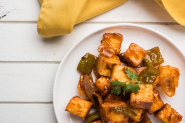 Baharatlı Paneer veya kuru biber paneer veya paneer tikka veya süzme peynir, kırmızı biber ve soğan, favori Hint başlangıç menüsü, seçici odak ile beyaz yemek servis