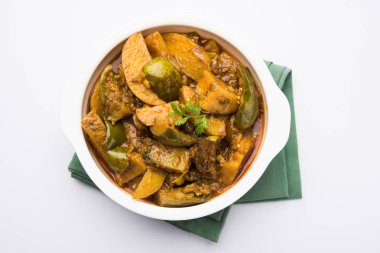 Hint baingan veya baigan ve aalu sabzi / Aloo Baingan tarifi / Hint baharatlı patlıcan ve patates köri, kadhai veya beyaz kase, seçici odak servis