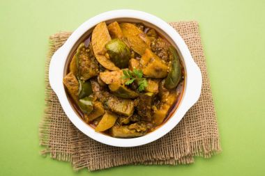 Hint baingan veya baigan ve aalu sabzi / Aloo Baingan tarifi / Hint baharatlı patlıcan ve patates köri, kadhai veya beyaz kase, seçici odak servis