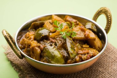 Hint baingan veya baigan ve aalu sabzi / Aloo Baingan tarifi / Hint baharatlı patlıcan ve patates köri, kadhai veya beyaz kase, seçici odak servis