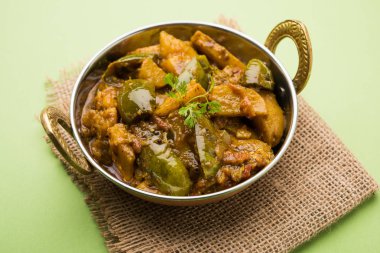 Hint baingan veya baigan ve aalu sabzi / Aloo Baingan tarifi / Hint baharatlı patlıcan ve patates köri, kadhai veya beyaz kase, seçici odak servis