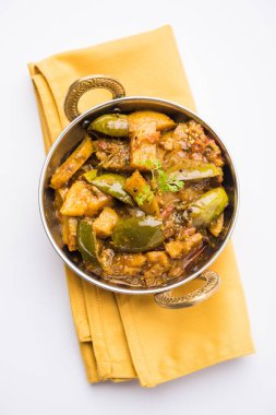 Hint baingan veya baigan ve aalu sabzi / Aloo Baingan tarifi / Hint baharatlı patlıcan ve patates köri, kadhai veya beyaz kase, seçici odak servis