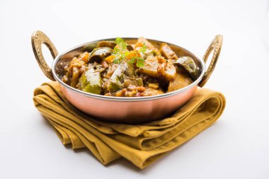 Hint baingan veya baigan ve aalu sabzi / Aloo Baingan tarifi / Hint baharatlı patlıcan ve patates köri, kadhai veya beyaz kase, seçici odak servis