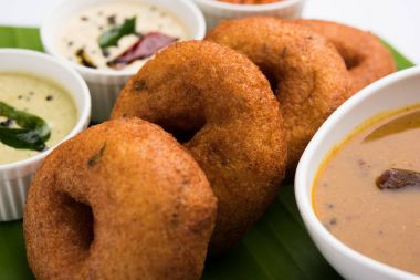 south indian food called vada sambar or sambar vada or wada, served with coconut, green and red chutney and south indian style hot coffee, selective focus clipart