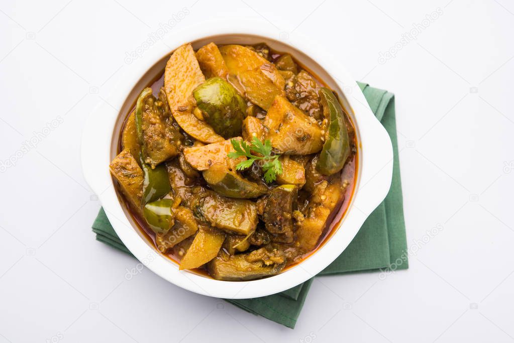 Indian baingan or baigan and aalu sabzi / Aloo Baingan Recipe / indian spicy eggplant and potato curry, served in kadhai or white bowl, selective focus