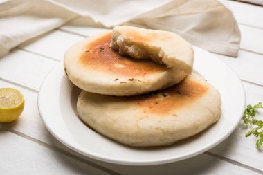 Kulcha is a type of leavened bread originated from the Indian Subcontinent; eaten in India and Pakistan, made from maida. Selective focus. Isolated clipart