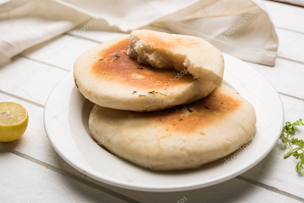 Kulcha is a type of leavened bread originated from the Indian Subcontinent; eaten in India and Pakistan, made from maida. Selective focus. Isolated
