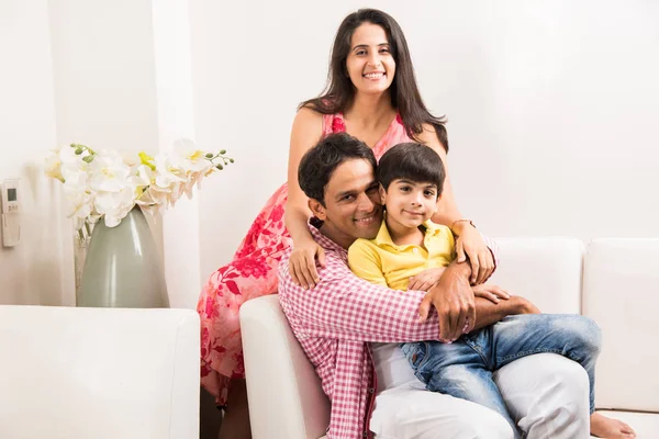 Upřímný portrét inteligentních indické rodiny čtyř zatímco sedí na pohovce. Indické nebo asijské rodinné skupinové foto. Selektivní fokus — Stock fotografie