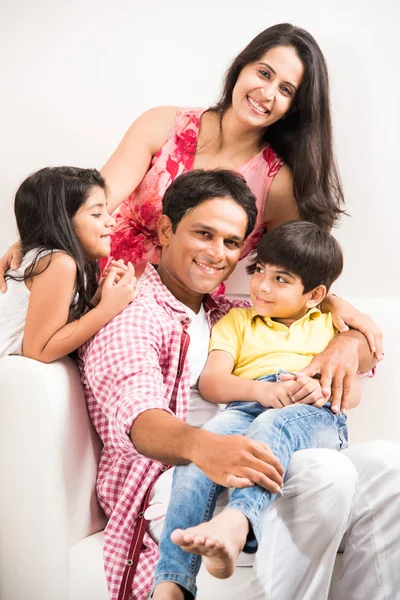 Upřímný portrét inteligentních indické rodiny čtyř zatímco sedí na pohovce. Indické nebo asijské rodinné skupinové foto. Selektivní fokus — Stock fotografie