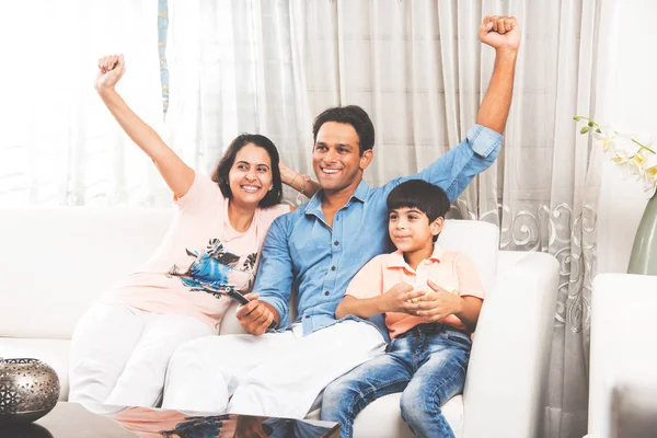 Indian young Family of 3 Sitting On Sofa while Watching TV Together, selective focus — Stock Photo, Image