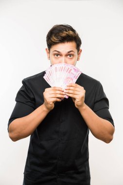 Beyaz arka planda tek başına dururken elinde banknot tutan yakışıklı Hintli adam.