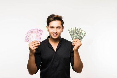 Beyaz arka planda tek başına dururken elinde banknot tutan yakışıklı Hintli adam.