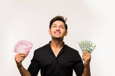 Beyaz arka planda tek başına dururken elinde banknot tutan yakışıklı Hintli adam.