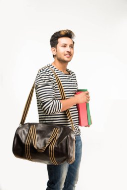 Yakışıklı Hintli erkek üniversite öğrencisi kitap ve çantayla duruyor, beyaz arka plana karşı, izole