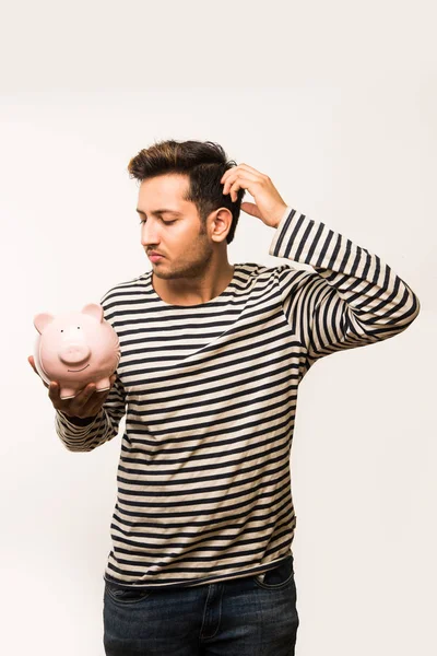 Kumbaralı Hintli yakışıklı genç adam ya da para kutusu farklı ifadelerle poz veren, beyaz arka planda tek başına duran