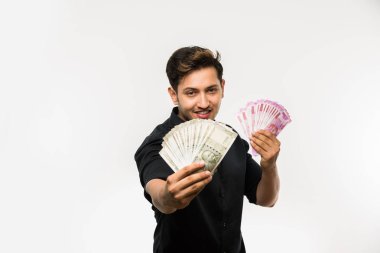 Yakışıklı Hintli adam elinde kağıt para banknotları tutuyordu. 500 ya da 2000 rupi, beyaz arka planda tek başına duruyordu.