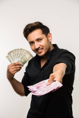 Yakışıklı Hintli adam elinde kağıt para banknotları tutuyordu. 500 ya da 2000 rupi, beyaz arka planda tek başına duruyordu.