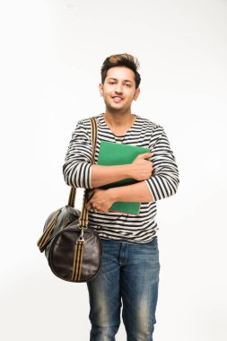 Yakışıklı ve genç Hintli erkek üniversite öğrencisi kolej kitaplar, dizüstü bilgisayar ya da akıllı telefon tutarak beyaz arka plan üzerinde çanta