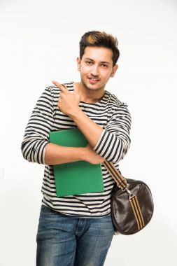 Yakışıklı ve genç Hintli erkek üniversite öğrencisi kolej kitaplar, dizüstü bilgisayar ya da akıllı telefon tutarak beyaz arka plan üzerinde çanta