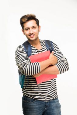 Yakışıklı ve genç Hintli erkek üniversite öğrencisi kolej kitaplar, dizüstü bilgisayar ya da akıllı telefon tutarak beyaz arka plan üzerinde çanta