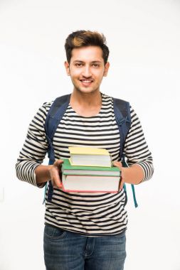 Yakışıklı ve genç Hintli erkek üniversite öğrencisi kolej kitaplar, dizüstü bilgisayar ya da akıllı telefon tutarak beyaz arka plan üzerinde çanta